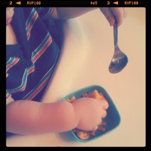 baby hands eating macaroni