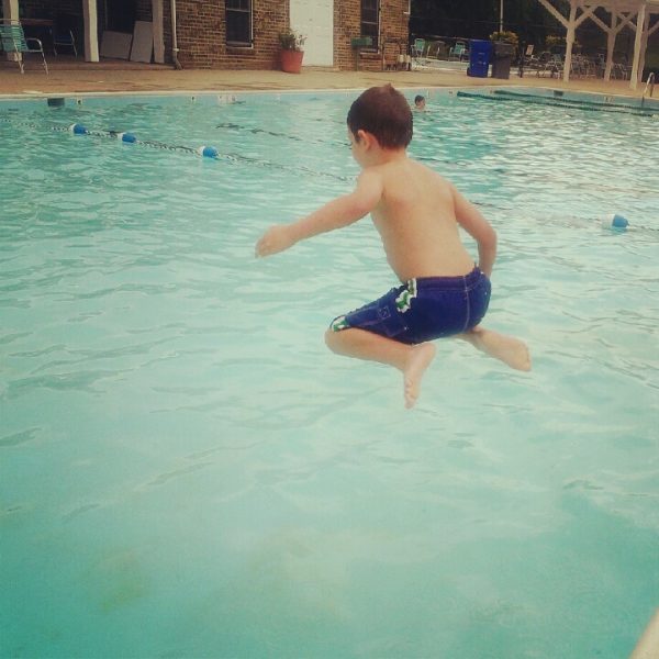 young boy jump in the pool