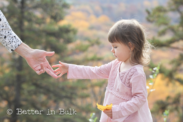 little girl reaching for her dad's hand